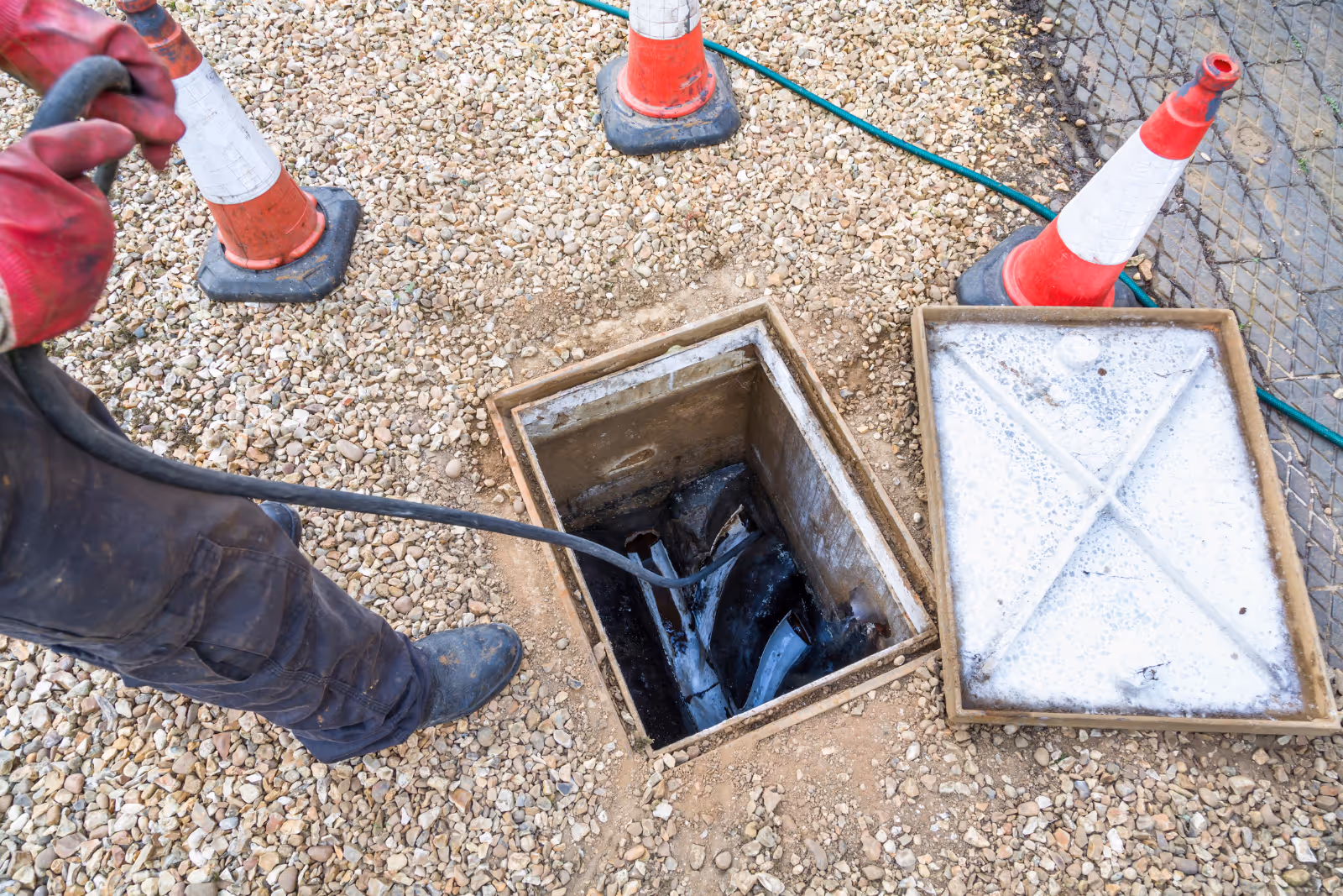 A plumber cleans out a drain, using tools to remove debris